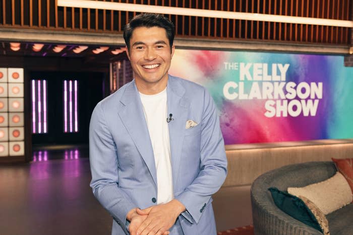 Henry Golding smiles in a blue blazer on 'The Kelly Clarkson Show'