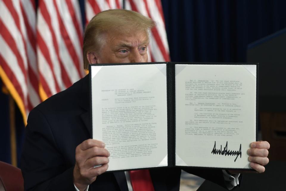 El presidente Donald Trump firma una orden ejecutiva durante una conferencia de prensa en el Trump National Golf Club en Bedminster, Nueva Jersey, el sábado, 8 de agosto de 2020 (AP Photo / Susan Walsh).