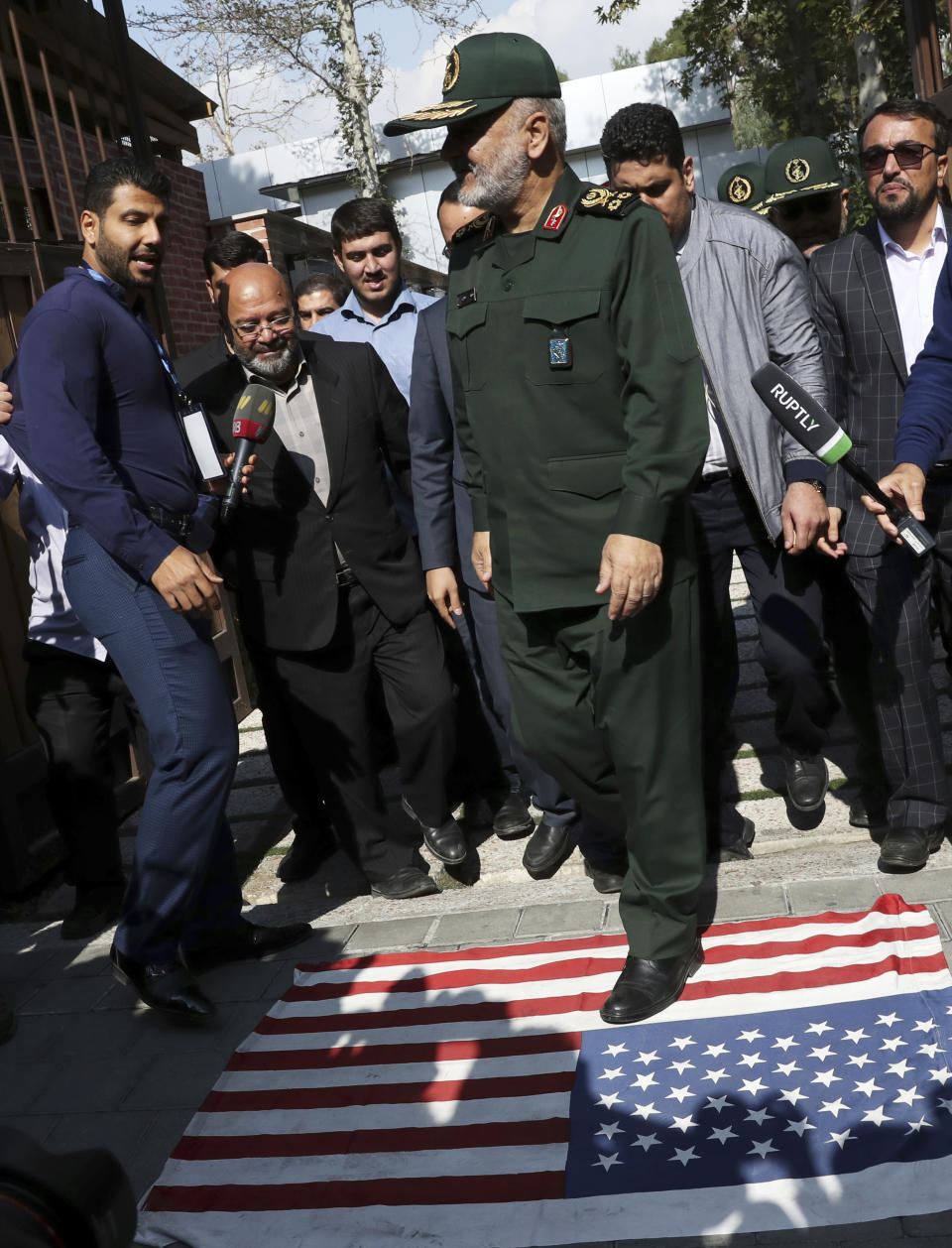 Chief of Iran's Revolutionary Guard Gen. Hossein Salami attends a ceremony to unveil new anti-U.S. murals painted on the walls of former U.S. embassy in Tehran, Iran, as he steps on the U.S. flag. Saturday, Nov. 2, 2019. Anti-U.S. works of graphics is the main theme of the wall murals painted by a team of artists ahead of the 40th anniversary of the takeover of the U.S. diplomatic post by revolutionary students. (AP Photo/Vahid Salemi)