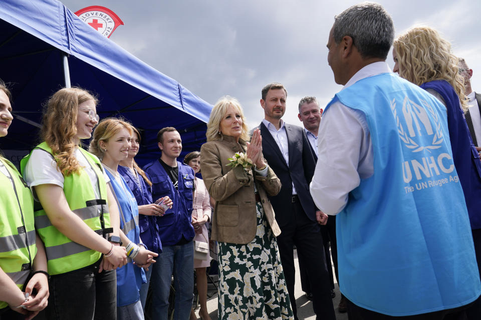 First lady Jill Biden speaks as she talks with a United Nations Refugee Agency worker during a visit to Vysne Nemecke, Slovakia, near the border with Ukraine, Sunday, May 8, 2022. Slovakia's Prime Minister Eduard Heger stands next to Biden at right. (AP Photo/Susan Walsh, Pool)