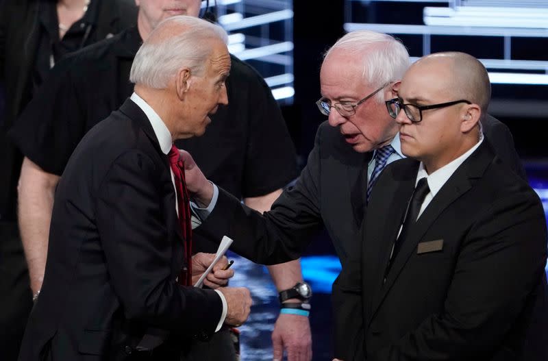 FILE PHOTO: Senator Bernie Sanders talks with former Vice President Joe Biden at the end of at the ninth Democratic 2020 U.S. Presidential candidates debate at the Paris Theater in Las Vegas