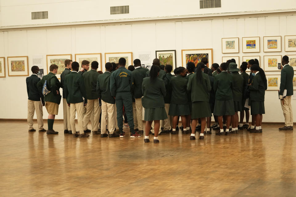 Schoolchildren look at paintings done in the 1940s and 1950s by young Black students at Cyrene Mission School at the National Gallery of Zimbabwe, Wednesday July 27, 2022. The paintings are part of a historic exhibit, "The Stars are Bright," now showing in Zimbabwe for the first time since the collection left the country more than 70 years ago. (AP Photo/Tsvangirayi Mukwazhi)