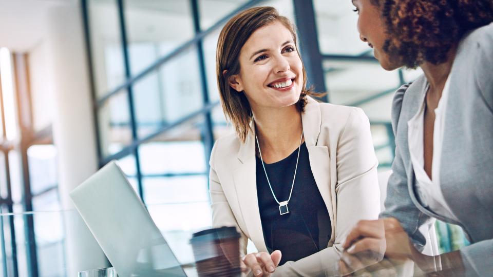 Shot of two young businesswomen using a laptop together at work.