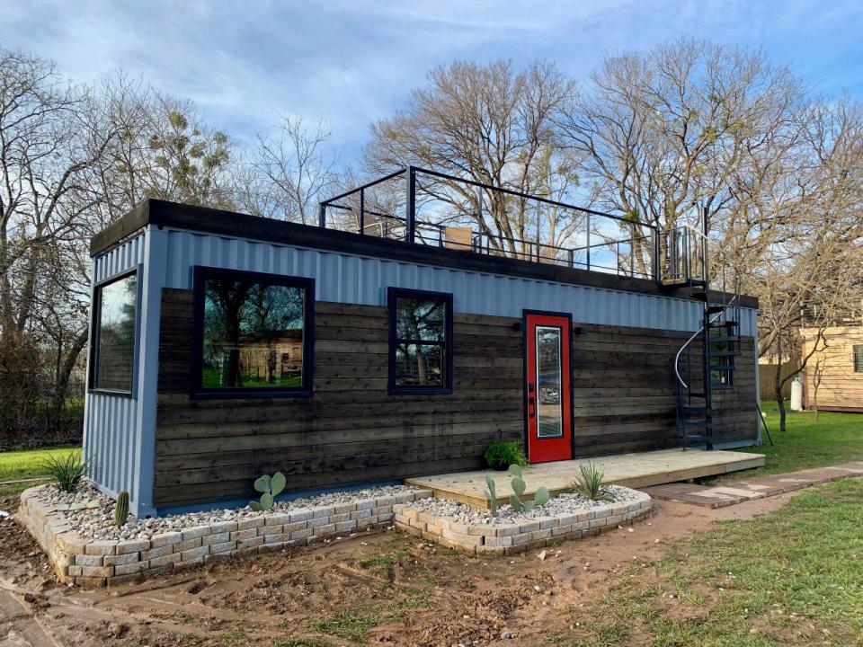 The "Mainsail," a tiny 40-foot container home located in Waco, Texas, features modern, luxurious furniture and a rooftop deck lit by LED lights.