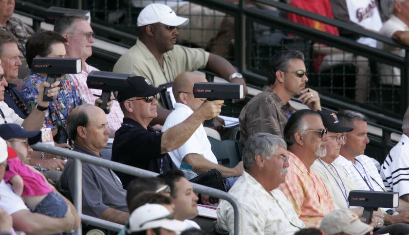 MLB scouts sit in the stands and point radar guns at the field during a 2007 spring training game