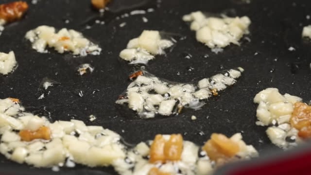 Frying garlic and lard in frying pan