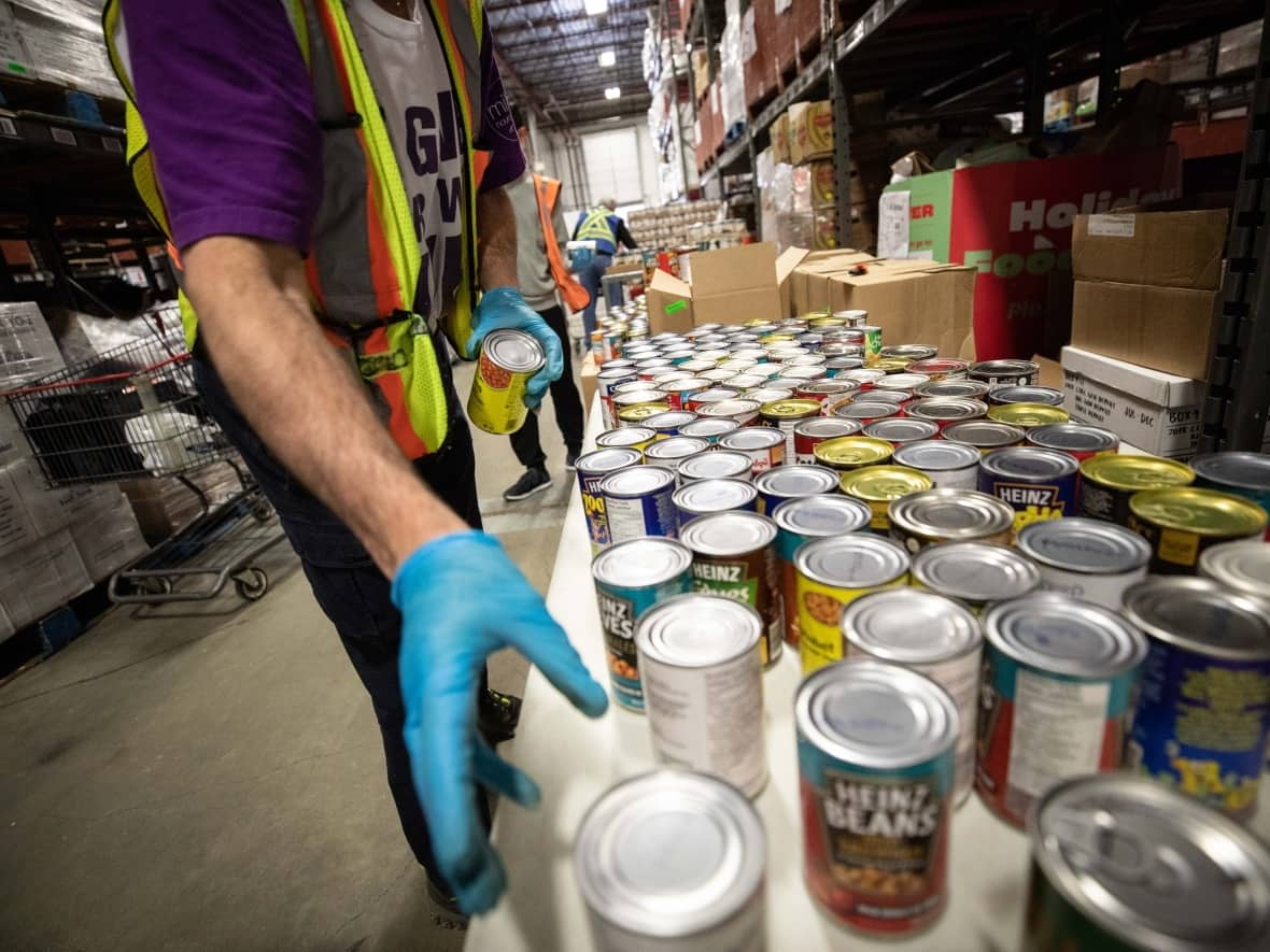 Volunteers fill bags with food at the Greater Vancouver Food Bank in Burnaby on Tuesday, March 17, 2020. Meaghon Reid, executive director, Vibrant Communities Calgary says there has been a huge increase in the amount of people using food bank services.  (Maggie MacPherson/CBC - image credit)