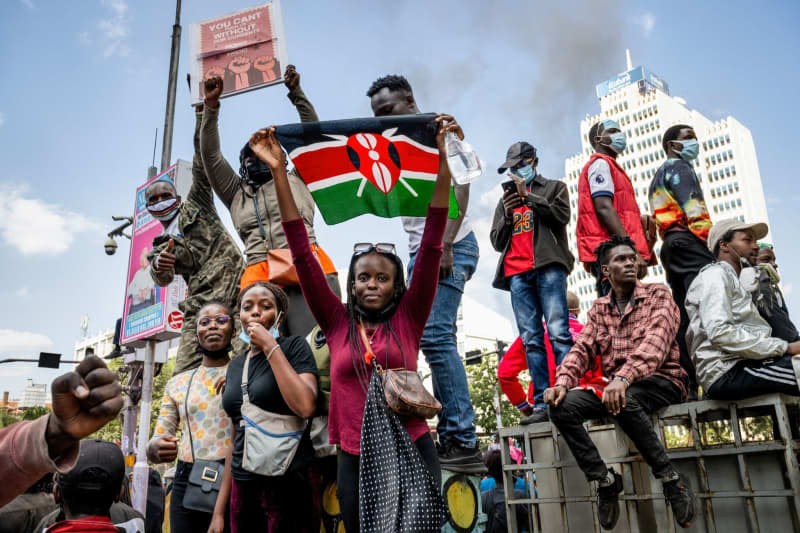 A protester holds a Kenyan flag during the nationwide demonstrations against proposed taxes in the Finance Bill 2024 in Nakuru Town. Several people were killed and many injured after police opened fire on the protesters. Katie G. Nelson/SOPA Images via ZUMA Press Wire/dpa