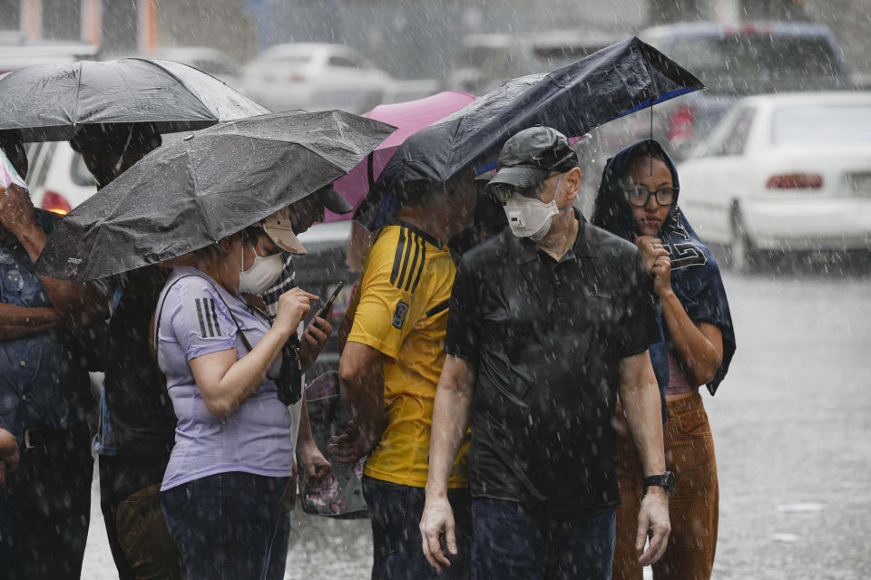 Personas hacen fila en medio de una fuerte lluvia para votar en las elecciones primarias de la oposición en Caracas, Venezuela, el domingo 22 de octubre de 2023. La oposición elegirá un candidato para desafiar al presidente Nicolás Maduro en las elecciones presidenciales de 2024. (Foto AP/Matías Delacroix)