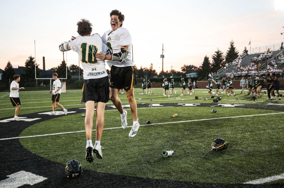 St. X 's Tyler Jurgenson, left, celebrates with teammate John Carlon after the Tigers won  the state championship lacrosse title after defeating South Oldham in Monday night's state lacrosse championship game. May 22, 2023.