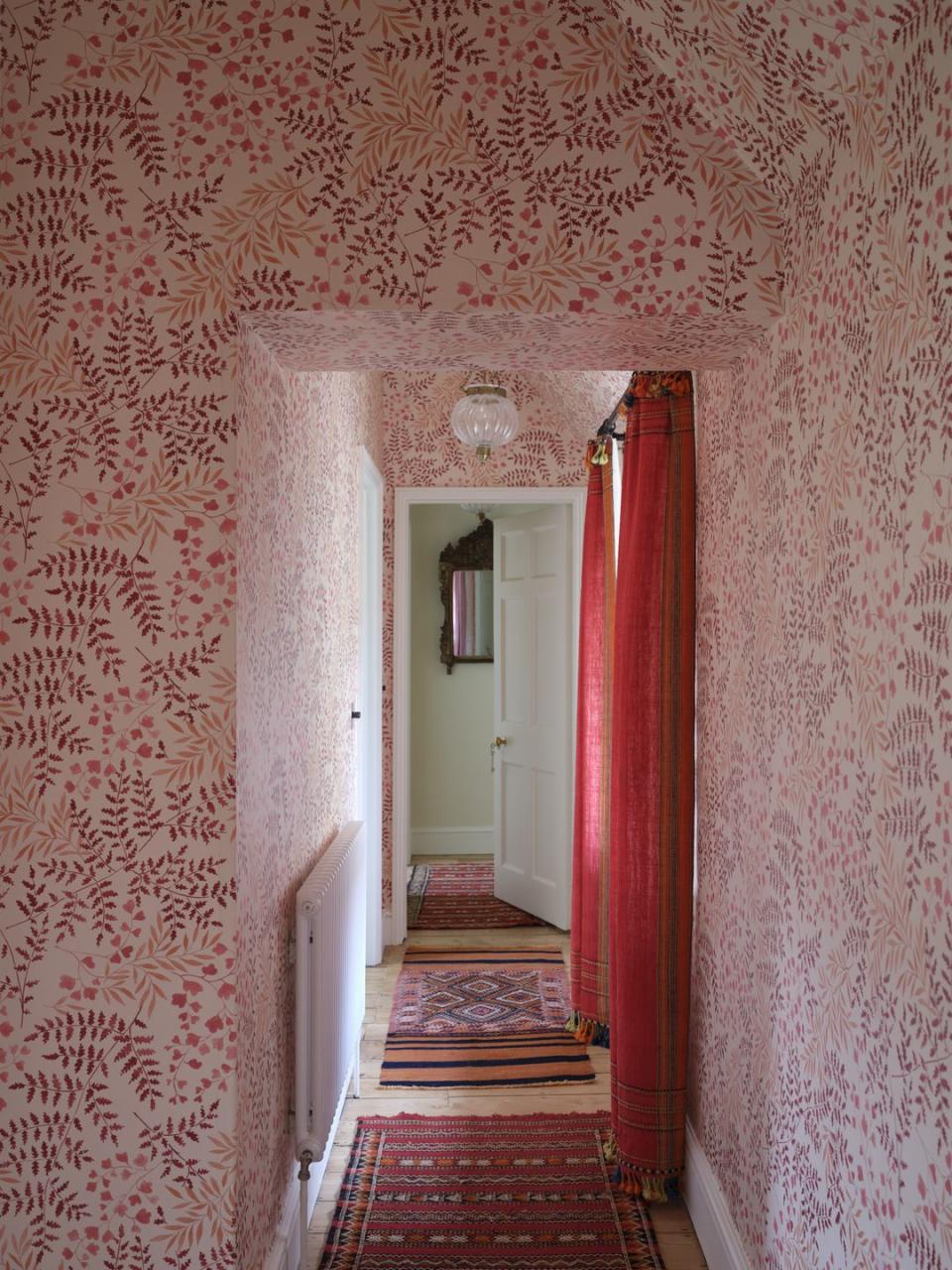 hallway with red botanical wallpaper and red curtains