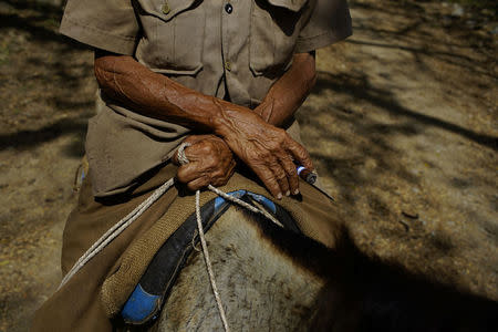 Hipolito Marrero, 83, smokes a cigar as he commutes on horseback in the mountains near the village of Santo Domingo, in the Sierra Maestra, Cuba, March 31, 2018. REUTERS/Alexandre Meneghini