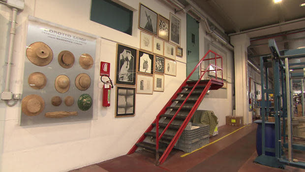 Fashion hangs on the walls next to the fire extinguishers at the Bonotto Fabrics factory. / Credit: CBS News