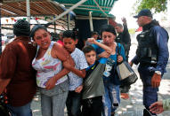 <p>Police officers disperse the relatives of prisoners who were waiting to hear news about their family members imprisoned at a police station when a riot broke out, in Valencia, Venezuela, Wednesday, March 28, 2018. In a state police station housing more than one hundred prisoners, a riot culminated in a fire, requiring authorities to open a hole in a wall to rescue the inmates. (AP Photo/Juan Carlos Hernandez) </p>