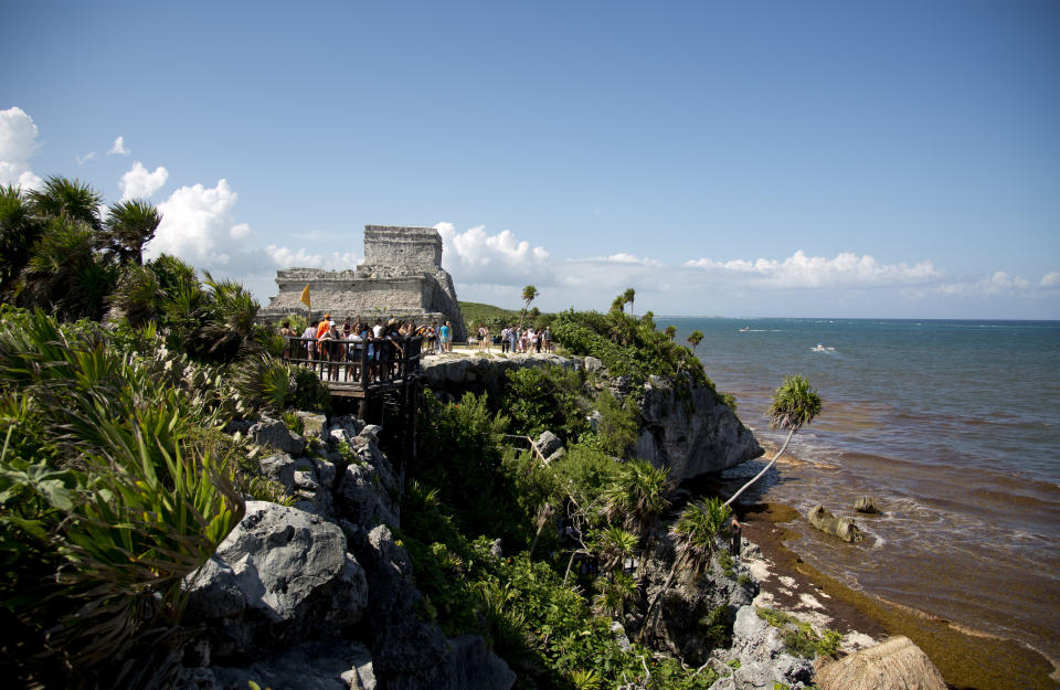 In this Aug. 5, 2018 photo, tourists vist the archeological site of Tulum on Mexico's Yucatan Peninsula. Almost seven million international tourists visit this stretch of coast every year; many of whom arrive at the Cancun airport and are bused or drive down the coast. (AP Photo/Eduardo Verdugo)