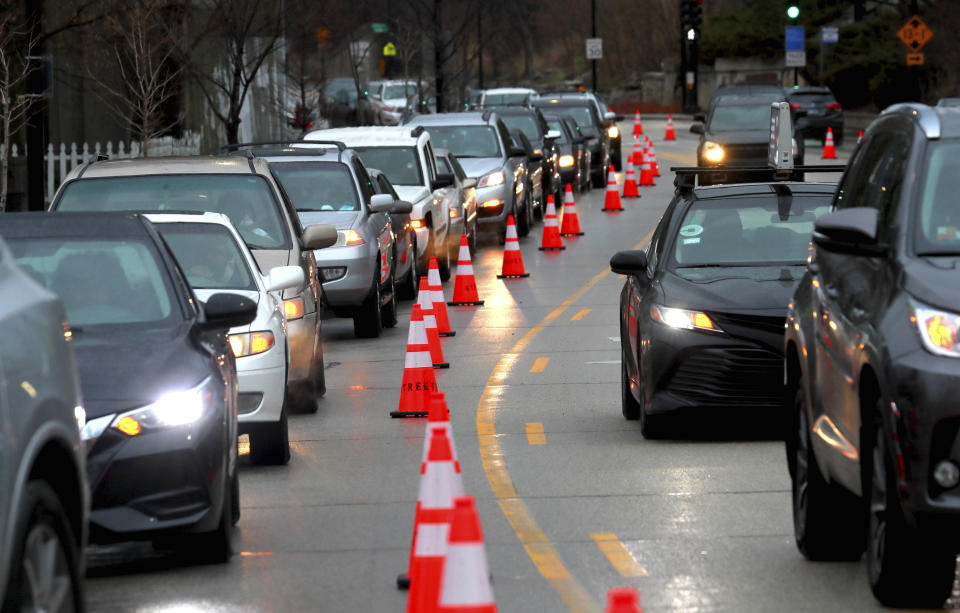 Cars line up early morning along Green Bay Road waiting to receive free gas donated by Willie Wilson at the Mobil Gas Station on Thursday, March 24, 2022, in Evanston, Ill. (Stacey Wescott/Chicago Tribune via AP)