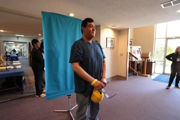 Mario Aleman gets his photo taken for his driver's license during a free clinic Wednesday, May 8, 2024 at Second Missionary Baptist Church in Battle Creek.