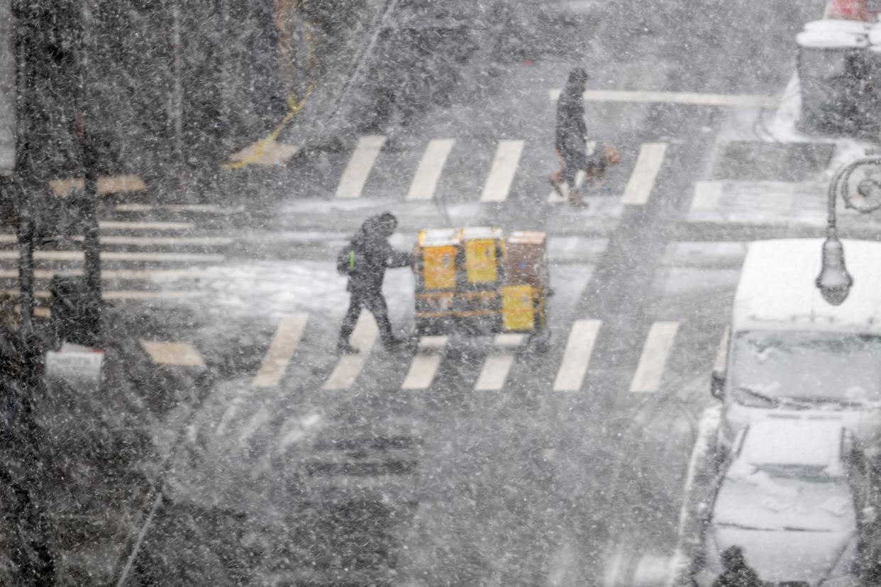 People walk through the blowing snow in Manhattan on 13 February 2024 in New York City (Getty Images)