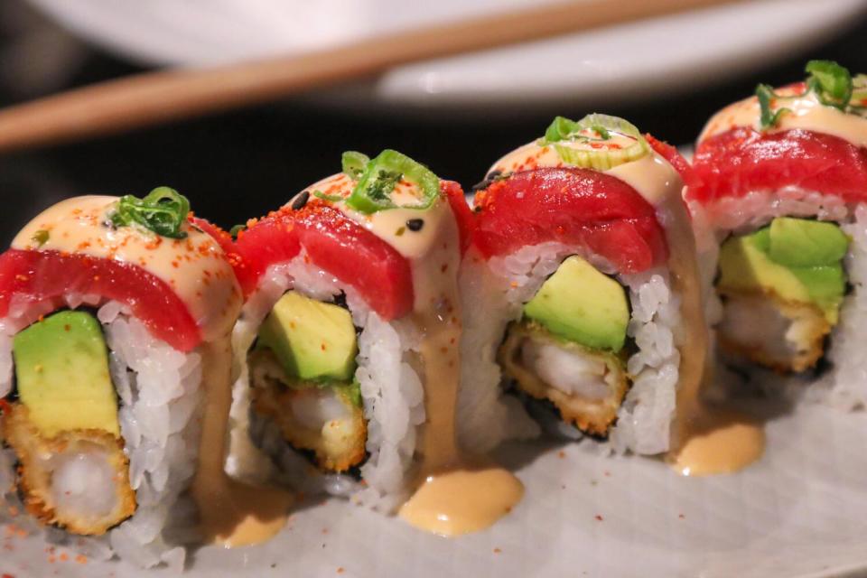 A plate of acebichado with crispy shrimp, avocado topped with tuna, acebichado sauce, togarashi, green onion.