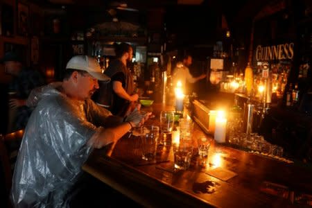 People sit at a bar that has no power and drink during a