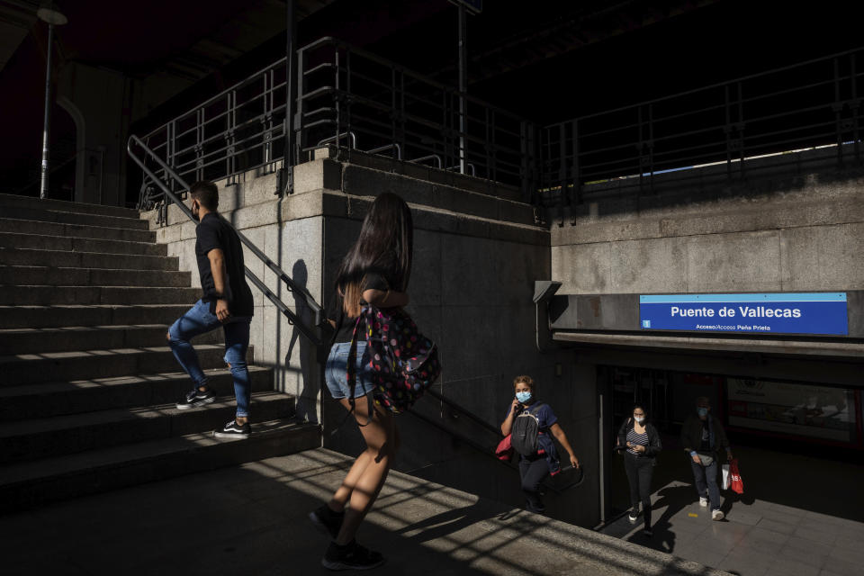 Commuters at the subway station in the southern neighbourhood of Vallecas in Madrid, Spain, Monday, Sept. 21, 2020. Police in the Spanish capital and its surrounding towns are stopping people coming in and out of working-class neighborhoods that have been partially locked down to stem Europe's fastest coronavirus spread. (AP Photo/Bernat Armangue)