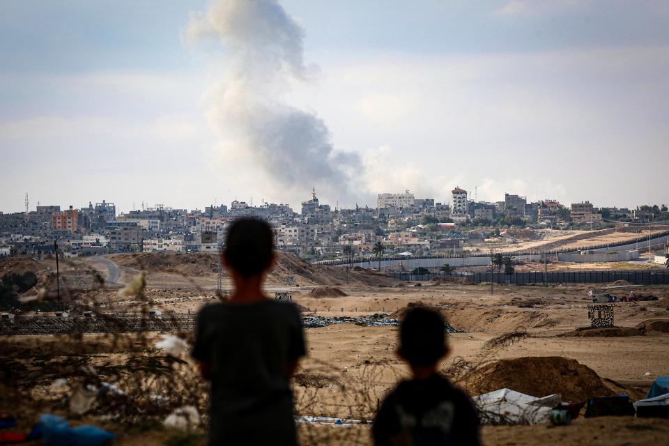 Boys watch smoke billowing during Israeli strikes east of Rafah in the southern Gaza Strip on May 13, 2024, amid the ongoing conflict between Israel and the Palestinian militant group Hamas.