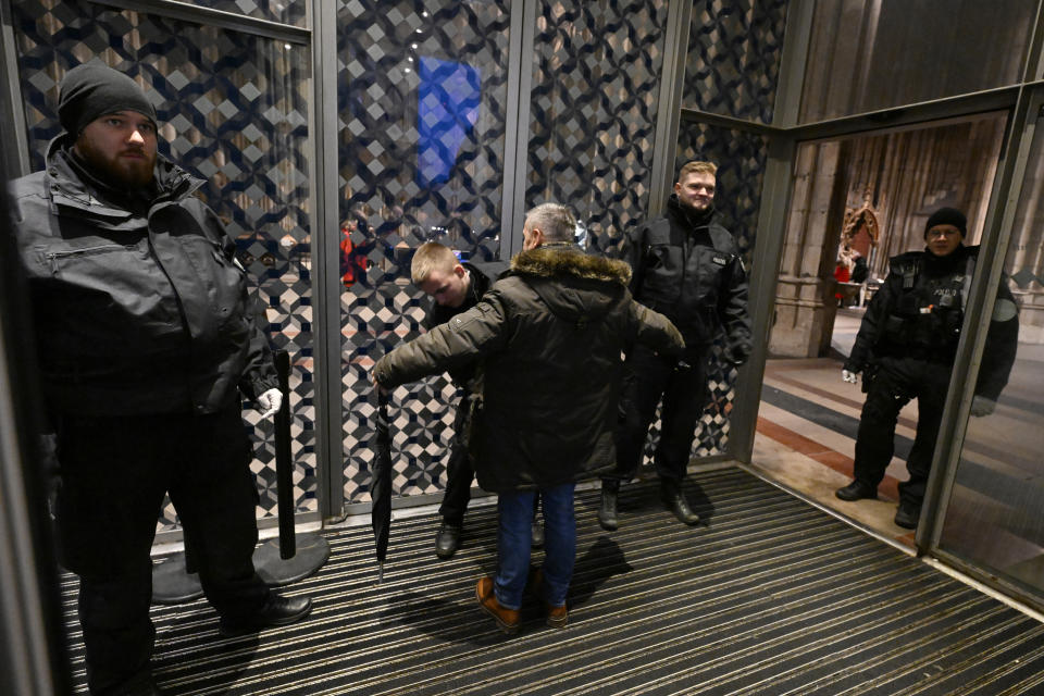 A man is searched at the entrance of Cologne Cathedral ahead of a Christmas Eve Mass, in Cologne, Germany, early Sunday, Dec. 24, 2023. Cologne police acting on indications of a possible attack searched Germany's landmark cathedral with sniffer dogs Saturday and said worshippers attending Christmas Eve Mass would undergo security screening before being allowed in. (Roberto Pfeil/dpa via AP)