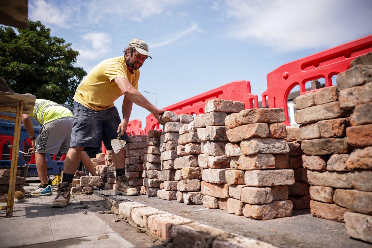 Kingswood Homes workers rebuild a wall outside the Southport Islamic Centre Mosque in Southport, Merseyside, after a protest as police officers suffered serious injuries when bricks, stones and bottles were thrown and cars were set alight during violent protests following a vigil for three girls killed in a knife attack at a Taylor Swift-themed holiday club on Monday. Picture date: Wednesday July 31, 2024.