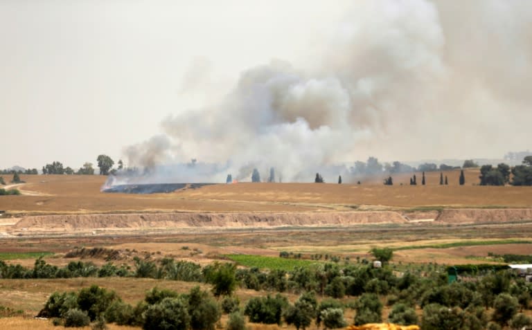 Smoke rises from an Israeli farming area after Palestinians flew a kite carrying a Molotov cocktail over the on border from Gaza on April 17, 2018