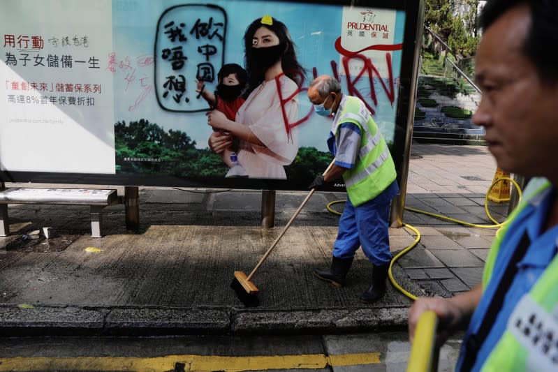 Cleaners wash a vandalized bus stop outside Kowloon Masjid and Islamic Centre in Hong Kong’s tourism district Tsim Sha Tsui