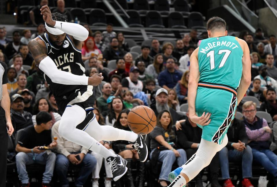 Bucks guard Wesley Matthews attempts to keep the ball inbounds as the Spurs' Doug McDermott gets out of the way during the first half Friday.