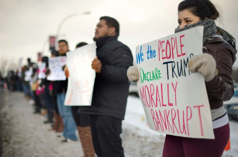 Demonstrators from The League of United Latin American Citizens of Iowa stand across the street in silent protest as supporters of Republic presidential candidate Donald Trump enter a campaign event in Marshalltown, Iowa, January 26, 2016