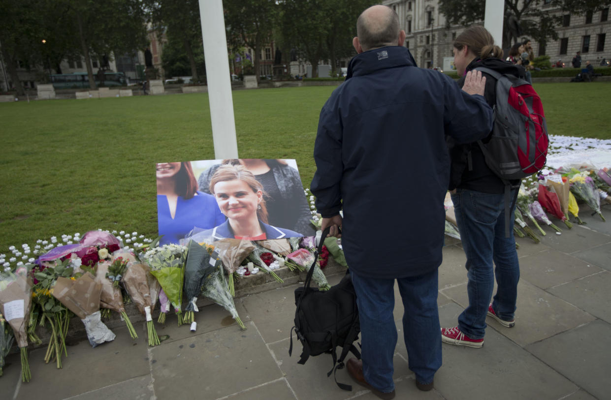 FILE - In this Friday, June 17, 2016 file photo, people look at tributes for Jo Cox, the 41-year-old British Member of Parliament shot to death yesterday in northern England, on Parliament Square outside the House of Parliament in London. Thomas Mair goes on trial, Monday Nov. 14, 2016, accused of murdering lawmaker Jo Cox, who was slain in the street a week before Britain's EU referendum in June. (AP Photo/Matt Dunham, File)