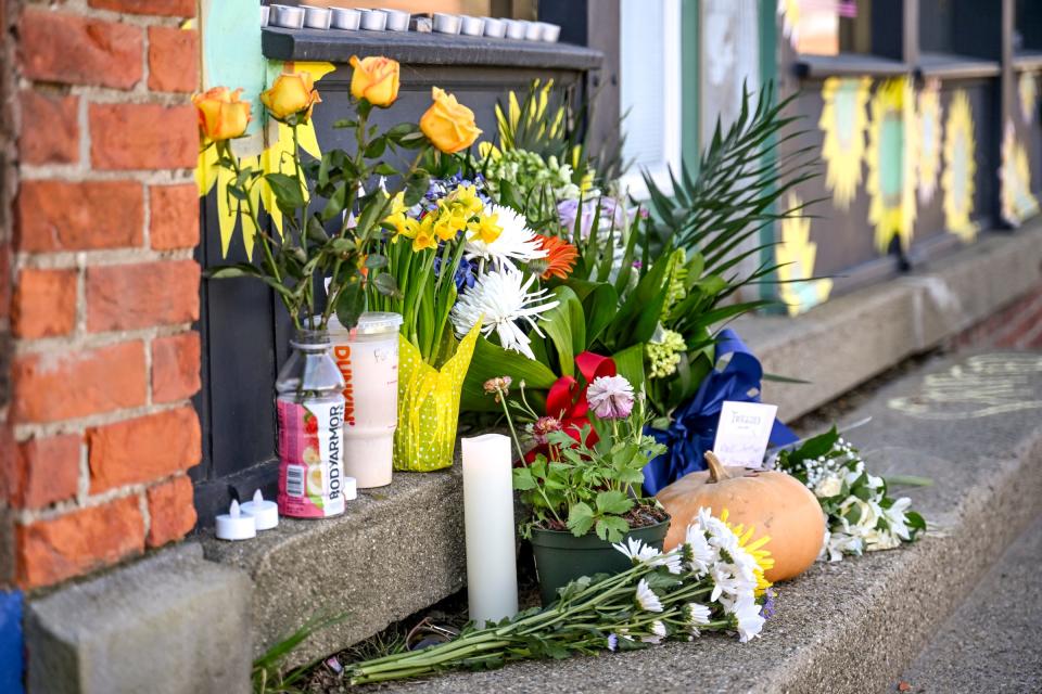 Flowers, notes and other items are placed outside Metro Retro as a memorial to owner Ted Stewart on Monday, April 1, 2024, in Old Town Lansing.