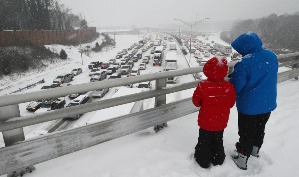 Pedestrians stop to look at the mess I-85 had become as motorists and pedestrians attempt to get home as the Triangle is pounded by a winter storm Wednesday Feb. 12, 2014 in Durham, NC. Chuck Liddy/File photo
