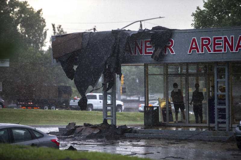 A group of people survey the damage to Buccaneer Arena from the building's lobby after a strong thunderstorm with high winds blew through the Des Moines metro in Urbandale, Iowa.