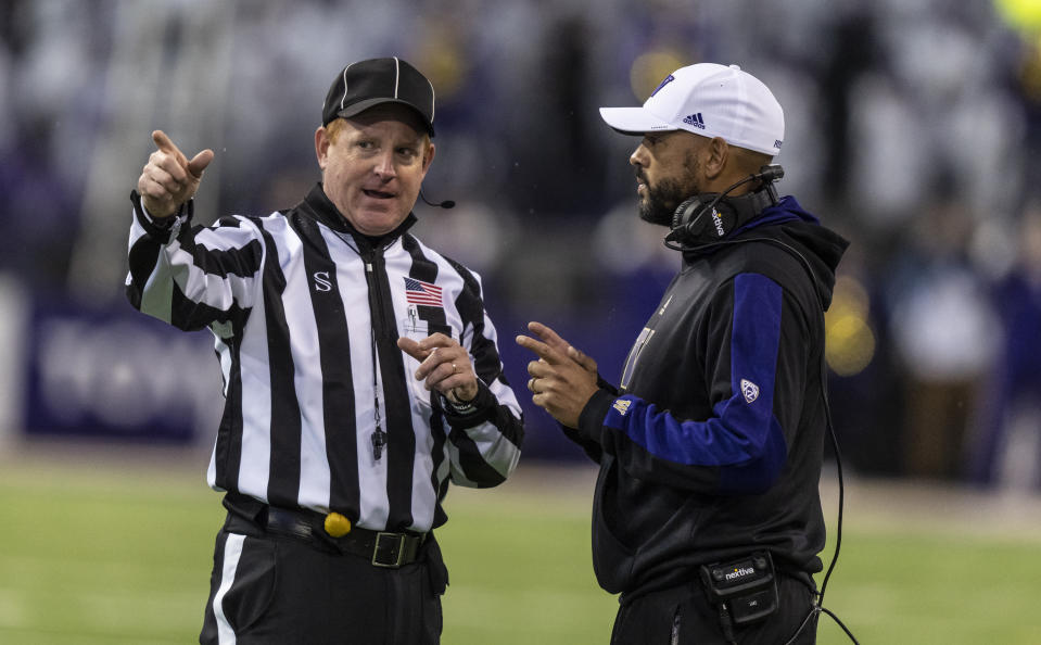 Washington head coach Jimmy Lake talks with line judge Bob Day during an NCAA college football game against Oregon, Saturday, Nov. 6, 2021, in Seattle. Oregon won 26-16. (AP Photo/Stephen Brashear)