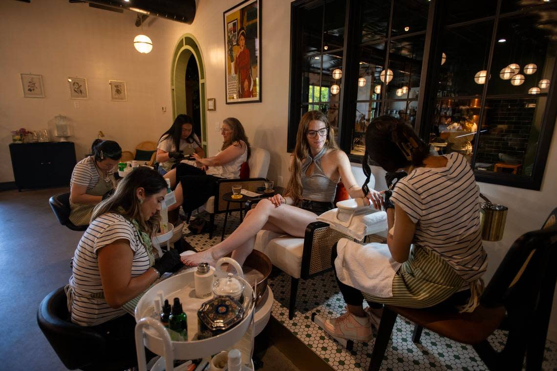 The staff at Moonshine and Nail Bar in Curtis Park do manicures and pedicures for Diane Marcus of Santa Cruz, left, and her daughter Grace Marcus of Davis, right, on her 21st birthday earlier this month.