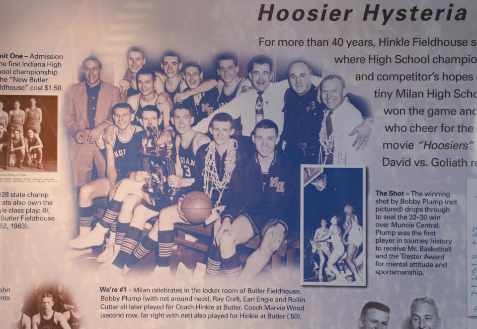 This image provided by Hinkle Fieldhouse shows a plaque hanging in Hinkle Fieldhouse in Indianapolis, Monday, May 4, 2020. The plaque tells the story of how the Milan High School basketball team won the 1954 Indiana state basketball championship, and features a group photo by team photographer William Crider. The team’s thrilling run to the Indiana state title is the basis for the movie "Hoosiers," voted the No. 1 sports movie of all time by the sports staff of The Associated Press. (Courtesy of Hinkle Fieldhouse via AP)