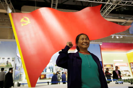 A visitor, a member of the Communist Party of China (CPC), poses for a photo during an exhibition displaying China's achievements for the past five years, as a part of the celebrations of the upcoming 19th National Congress of the Communist Party of China (CPC) at Beijing Exhibition Centre in Beijing, China October 10, 2017. REUTERS/Jason Lee