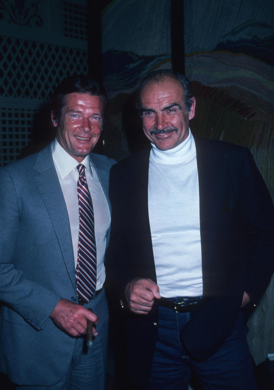 Roger Moore and Sean Connery smile while posing for a photo