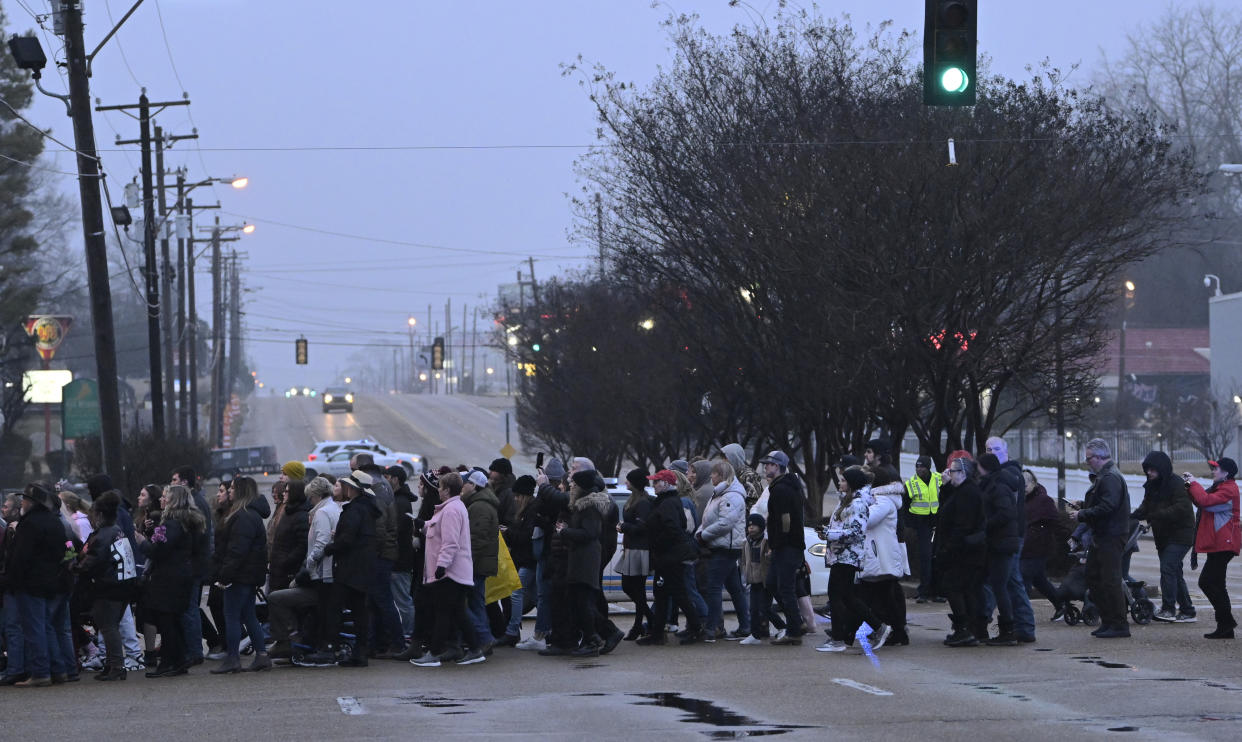 Fans cross Elvis Presley Blvd. to enter the main gate of Graceland during a memorial service for Lisa Marie Presley Sunday, Jan. 22, 2023, in Memphis, Tenn. She died Jan. 12 after being hospitalized for a medical emergency and was buried on the property next to her son Benjamin Keough, and near her father Elvis Presley and his two parents. (AP Photo/John Amis)