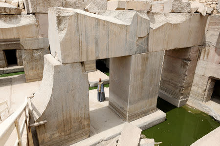 A worker stands beside the pond at new groundwater lowering project, behind Temple of Seti I, Abydos archeological site, Sohag, Egypt April 5, 2019. REUTERS/Mohamed Abd El Ghany TPX IMAGES OF THE DAY