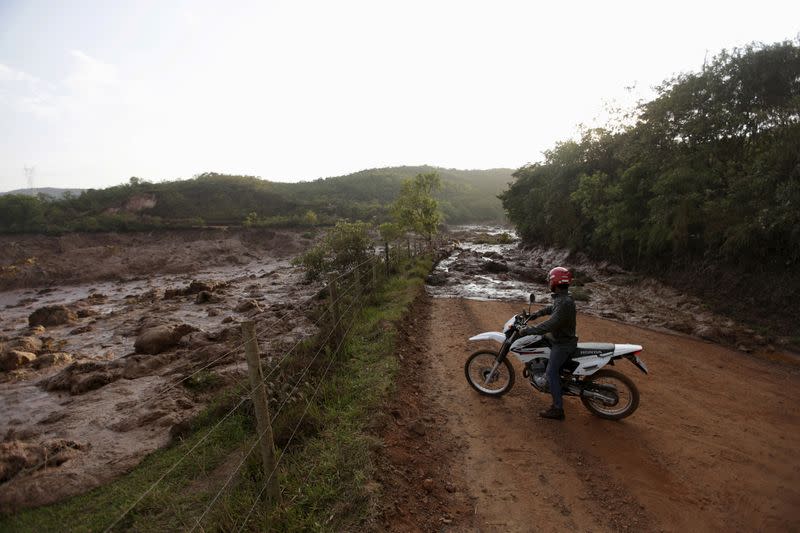 FILE PHOTO: A man observes a road blocked with mud after a dam owned by Vale SA and BHP Billiton Ltd burst in Mariana