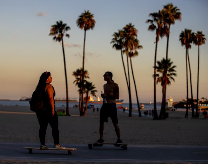 Long Beach, CA - August 28: Skateboarders take a sunset cruise along a cooler ocean's edge amid a hot summer day at Alamitos Beach in Long Beach, Sunday, Aug. 28, 2022. A heat wave is forecasted to take affect in Southern California this week. (Allen J. Schaben / Los Angeles Times)