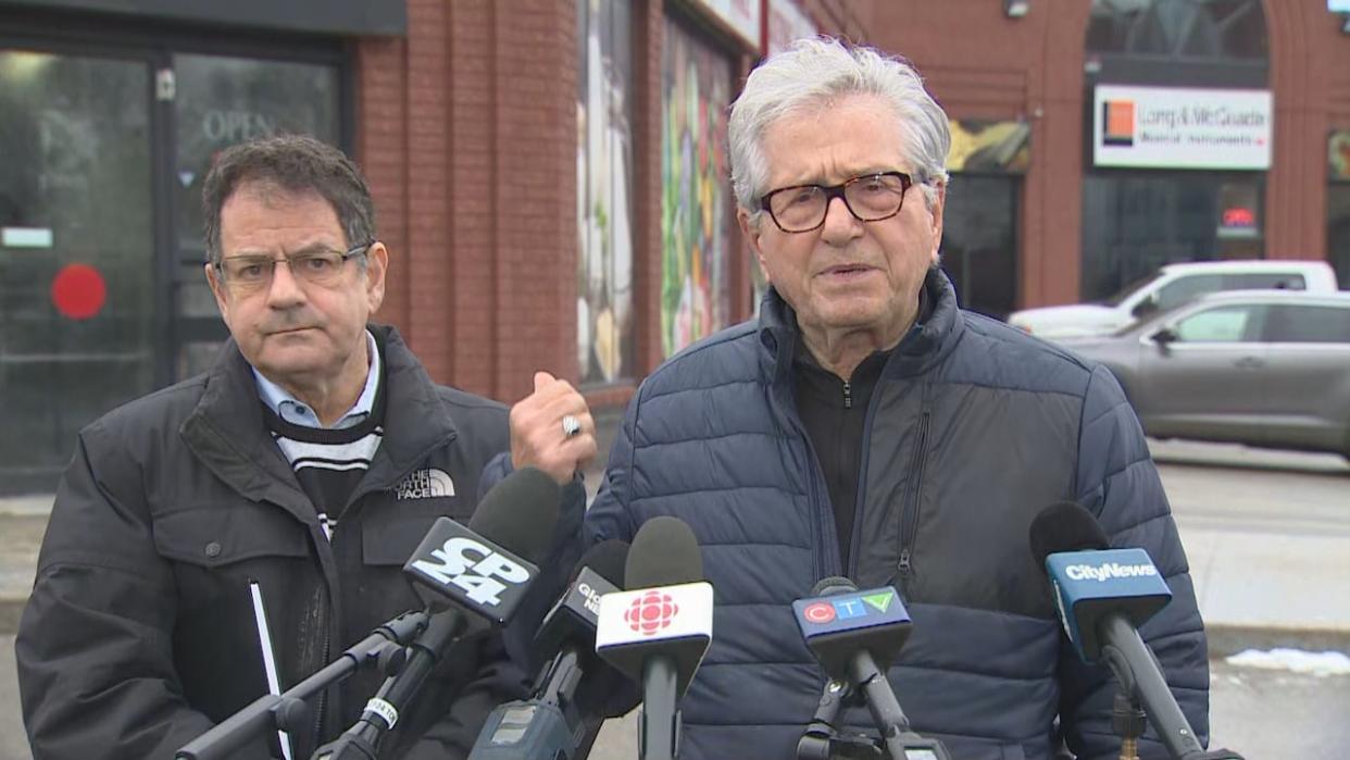 Coun. James Pasternak, left, and Coun. Mike Colle, right, speak to reporters on Monday outside a Jewish-owned delicatessen that police believe was intentionally set on fire early Jan. 3. (CBC - image credit)