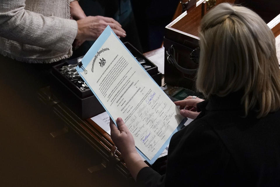 FILE - In this Jan. 7, 2021, file photo the signed certificate of Electoral College votes from Pennsylvania is held by a staff member during a joint session of the House and Senate to confirm the Electoral College votes cast in November's election, at the Capitol, in Washington. (AP Photo/Andrew Harnik, File)