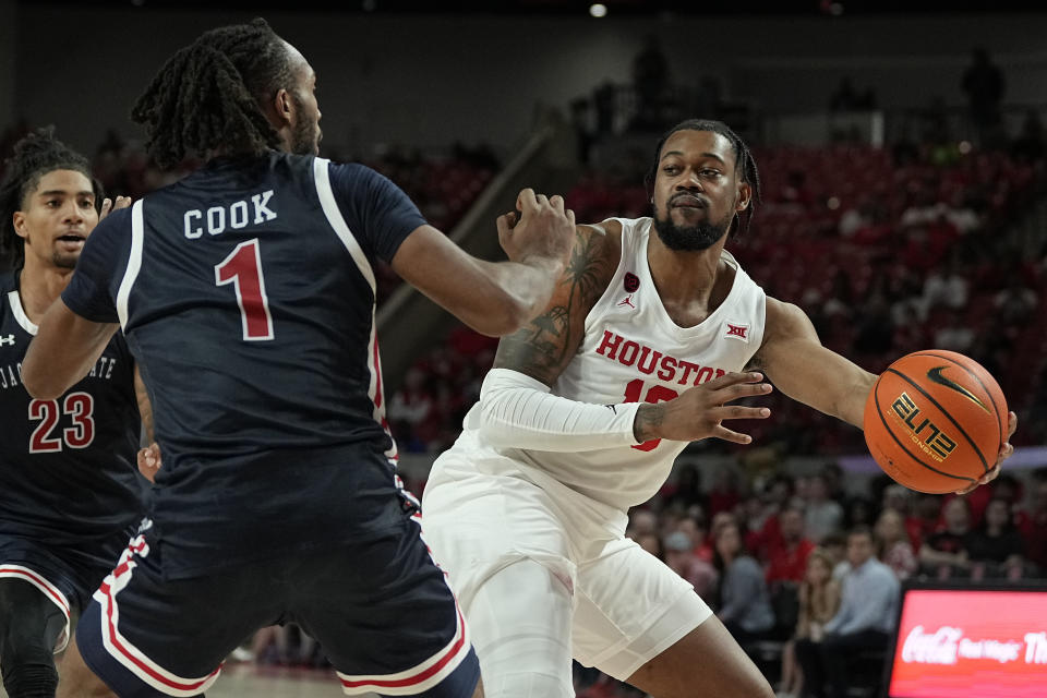 Houston forward J'Wan Roberts, right, passes the ball around Jackson State forward Zeke Cook (1) during the second half of an NCAA college basketball game, Saturday, Dec. 9, 2023, in Houston. (AP Photo/Kevin M. Cox)