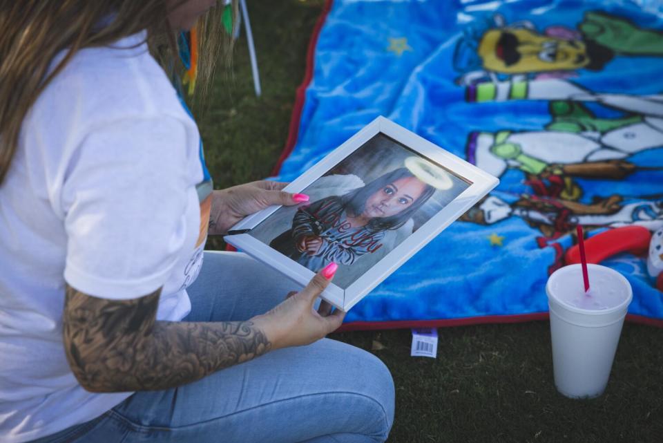 A family member holds a photo of 2-year-old Ezekiel Rivera.