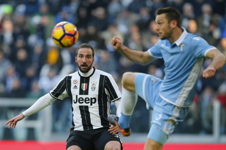 Juventus' forward Gonzalo Higuain(left) fights for the ball with Lazio's forward Cristiano Lombardi during their Serie A match at the Juventus Stadium in Turin on January 22, 2017